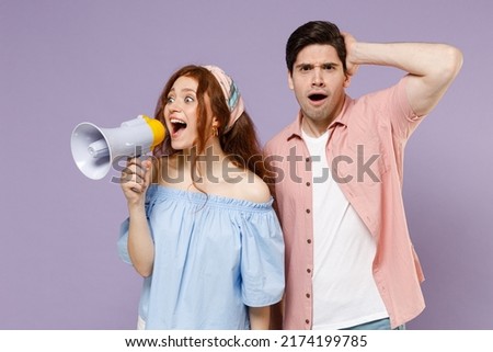 Two confused traveler tourist woman man couple in shirt scream aside in megaphone hot news hold head isolated on purple background Passenger travel abroad weekends getaway Air flight journey concept
