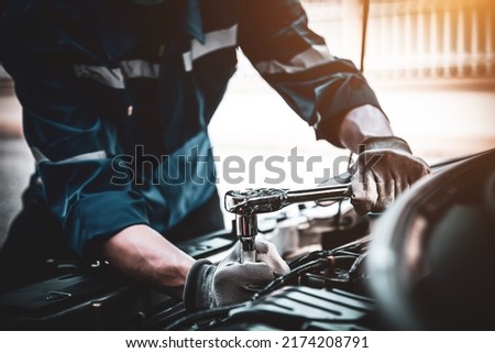 Car care maintenance and servicing, Close-up hand technician auto mechanic using the wrench to repairing change spare part car engine problem and car insurance service support. Royalty-Free Stock Photo #2174208791