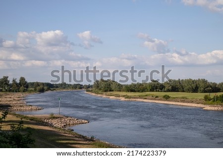 The Dutch river IJssel flows peacefully through the typical Dutch landscape. Royalty-Free Stock Photo #2174223379