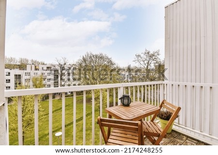 Front view of old brick buildings and cars with bicycles from small balcony with railings Royalty-Free Stock Photo #2174248255