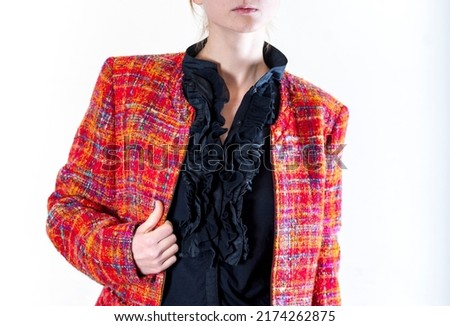 A portrait without a face of beautiful young woman in black blouse and red jacquard chanel style jacket