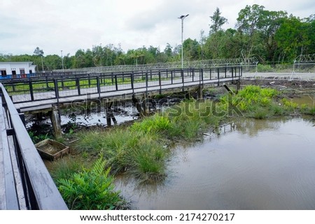 Guardrail for visitors and passengers at Ewer Asmat airport which is a swamp and mud land                        Royalty-Free Stock Photo #2174270217