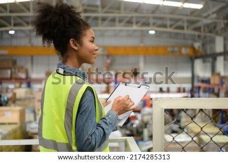 Female warehouse worker Counting items in an industrial warehouse on the factory's mezzanine floor. which is a storage for small and light electronic parts. Royalty-Free Stock Photo #2174285313