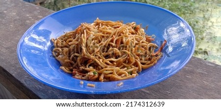 Merauke, Papua, Indonesia July 2022. this is a photo of fried noodles on a blue plate and ready to be served.