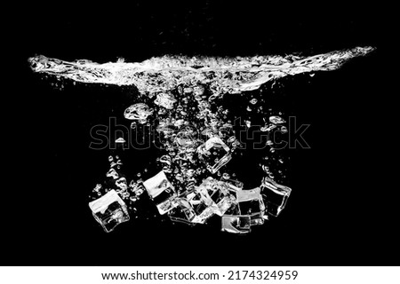studio shot ice cubes in splashing water on black background