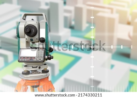 Device for surveyor. Optical theodelite on tripod. Place for text about geodesy. Equipment for topographic maps. Electronic theodelite for surveyor. Surveyor devise front blurred town. Royalty-Free Stock Photo #2174330211