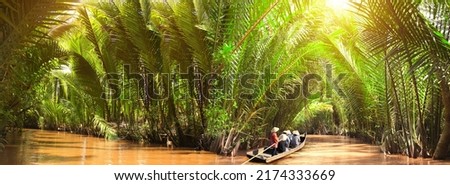 People boating in the delta of Mekong river, Vietnam, Asia. A tourist attraction - boat ride through Mekong delta canals Royalty-Free Stock Photo #2174333669