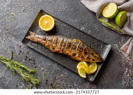 Fried sea bass on black plate top view Royalty-Free Stock Photo #2174337727