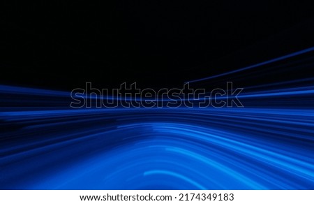 Blur futuristic glow. Neon abstract background. Sci-Fi illumination. Defocused luminous navy blue color curve lines light flare motion on dark black copy space.