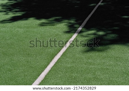 Green synthetic grass sports field with white line and shadows. Sports background for product display, banner, or mockup
