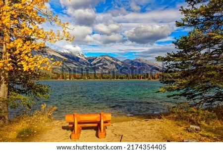 Bench on the shore of a mountain lake. Mountain lake view. Mountain lake shore. Mountain lake landscape Royalty-Free Stock Photo #2174354405