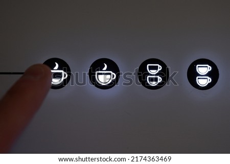 Finger pressing espresso button in automatic coffee machine. High quality photo