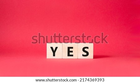 Yes symbol. Wooden blocks with word yes. Beautiful red background. Business and yes concept. Copy space.