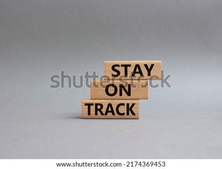 Stay on track symbol. Wooden blocks with words 'Stay on track'. Beautiful grey background. Business and 'Stay on track' concept. Copy space.