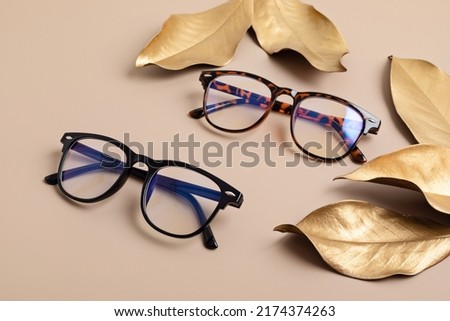 Stylish eyeglasses over pastel  background. Optical store, glasses selection, eye test, vision examination at optician, fashion accessories concept. Top view, flat lay Royalty-Free Stock Photo #2174374263