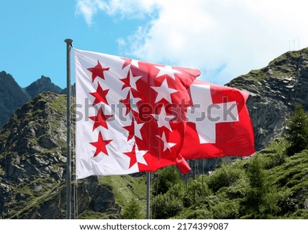 Swiss and Valais Flags, sight from mountain lake Dix, Valais, Switzerland, swiss alps the biggest dam in Europe. Royalty-Free Stock Photo #2174399087