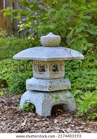 A stone Japanese lantern at a Japanese garden.