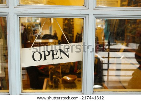 An open sign hanging in a door of a shop