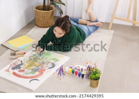 Creative of art concept, Young asian woman lying on the floor and work to painting art masterpiece.