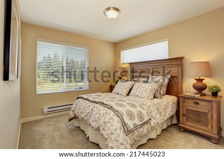 Beautiful bedroom in soft creamy color with rich carved wood furniture