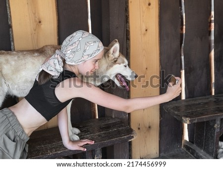 a girl takes a selfie with a dog on an excursion in a dog kennel