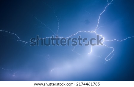 A strong storm with bright lightning illuminating ominous clouds. Exotic image of cloud texture. Adverse weather conditions. Photo wallpaper. Climate change. Force of nature. Beauty of earth. Royalty-Free Stock Photo #2174461785