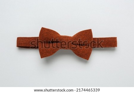 Stylish terracotta bow tie on white background, top view
