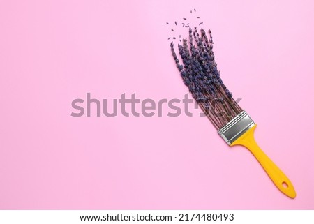 Creative flat lay composition with paint brush and lavender flowers on pink background. Space for text