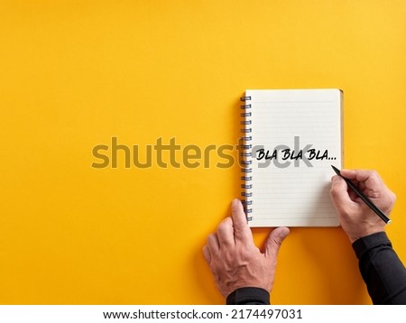 Male hand writing bla bla bla on a notepad. Business concept for talking too much with false information or gossip nonsense speaking. Royalty-Free Stock Photo #2174497031