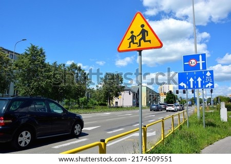 Children road sign on the road with moving cars