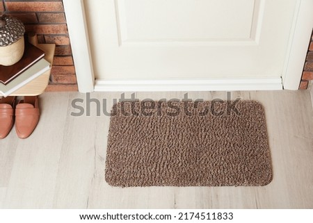 Grey door mat on wooden floor in hall, above view Royalty-Free Stock Photo #2174511833