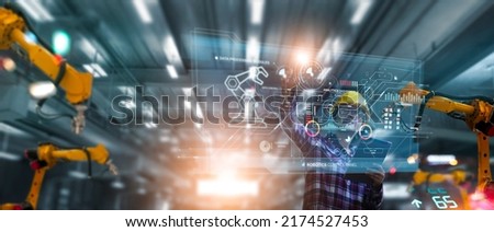 Industrial Engineer use modern dashboard interface and check and control automation robot arms in intelligent factory industrial on real time monitoring system software. Digital future manufacture. Royalty-Free Stock Photo #2174527453