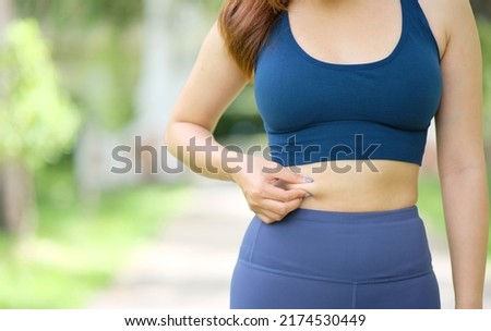 Woman with too much belly fat, woman with too much belly fat, feminist diet lifestyle concepts to reduce belly and shape healthy abdominal muscles. Royalty-Free Stock Photo #2174530449
