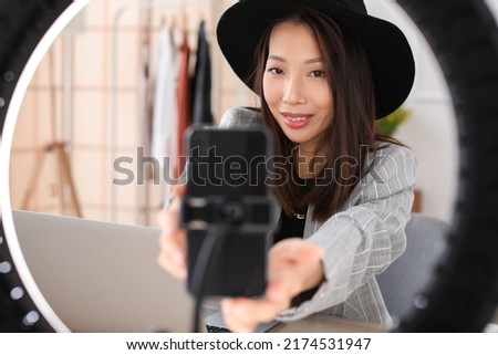 Female Asian blogger recording video in studio