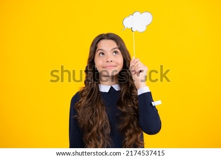 Teenager child girl holding thinking bubble, comment cloud over yellow background.