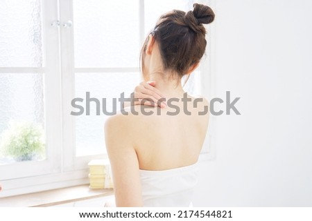 Asian woman taking her shoulder care at home Royalty-Free Stock Photo #2174544821