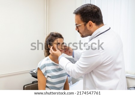 Adult woman having a visit at oculist's office. Doctor examining eyes of young woman in clinic.