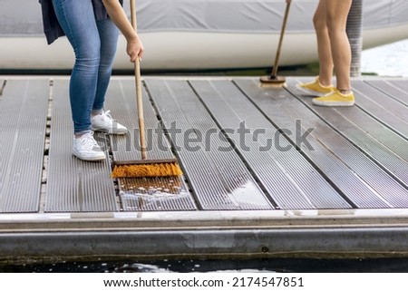 Cleaning Pier on Lake or Sea Beach. Pier Service  Yacht or Boat concept. Washing Pier floor with Brush Royalty-Free Stock Photo #2174547851