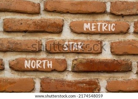 North star metric symbol. Concept words North star metric on red bricks on a beautiful brick wall background. Business, finacial and north star metric concept. Copy space.