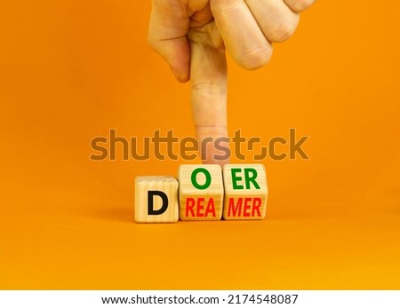 Doer or dreamer symbol. Concept words Doer or dreamer on wooden cubes. Businessman hand. Beautiful orange table orange background. Business and doer or dreamer concept. Copy space. Royalty-Free Stock Photo #2174548087