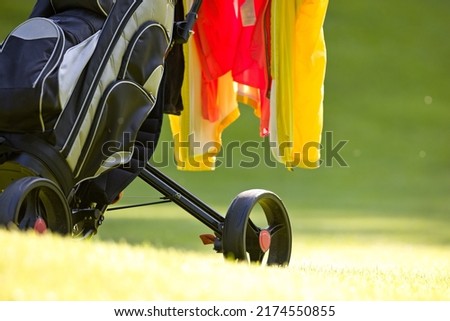 wheel of a golf cart with jackets over the handlebars