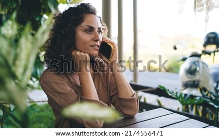Caucaisan woman in casual clothes spending daytime for calling and talking via cellular application, millennial female connecting to roaming internet for making international consultancy conversation Royalty-Free Stock Photo #2174556471