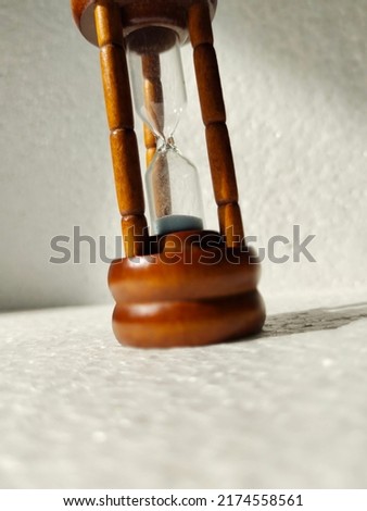 Close up sandhour on white styrofoam background. Low angle photography concept 