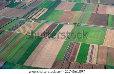 The grass is beautiful like an abstract picture. Farmland and a factory taken from an airplane take off over Strasbourg, France.