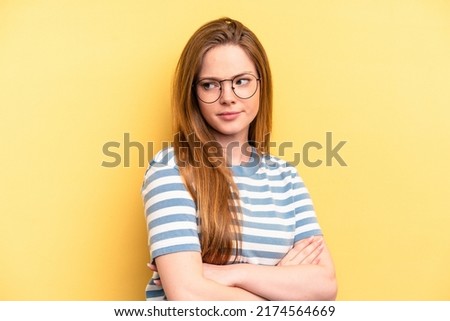 Young caucasian woman isolated on yellow background suspicious, uncertain, examining you. Royalty-Free Stock Photo #2174564669