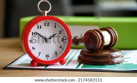 Close-up of judges gavel with alarm clock on financial documents. Postponement of a hearing, trial or auction end time. Court time and deadline concept Royalty-Free Stock Photo #2174583151