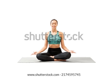 Attractive mixed race woman with closed eyes sitting cross-legged on a mat and practice deep breathing and meditation, isolated on white. Mental health, yoga, spiritual practice, focus, relax