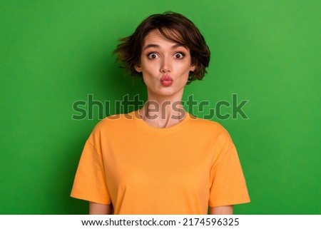 Photo of funky sweet young lady wear orange outfit sending you kiss isolated green color background