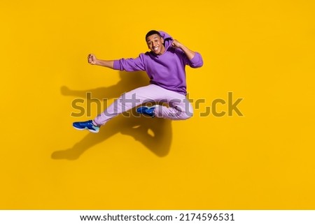 Full length body size view of handsome trendy strong guy jumping fighting isolated on bright yellow color background