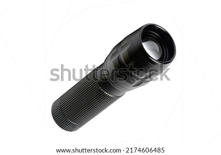 A metal flashlight is on white background. It is isolated black flashlight view.